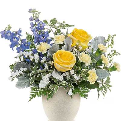 Yellow and blue floral arrangement in a beige vase