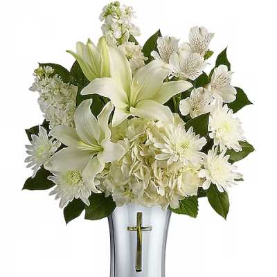 White lilies and chrysanthemums in a silver vase with a cross emblem
