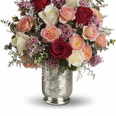 Bouquet of red, white, and blush roses in a silver vase