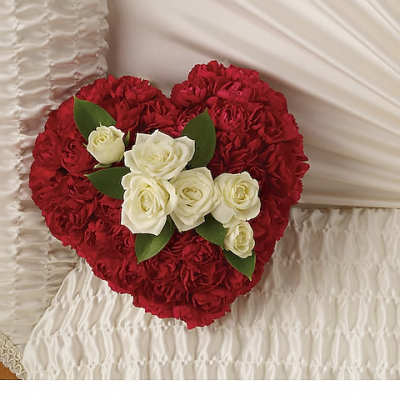 Heart-shaped red and white rose arrangement on a white fabric background