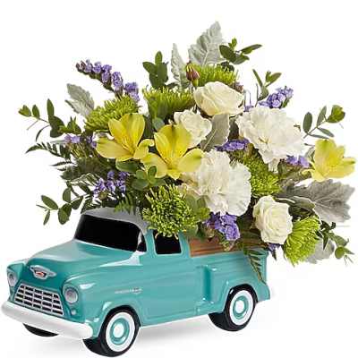 Flower arrangement in a turquoise pickup truck container