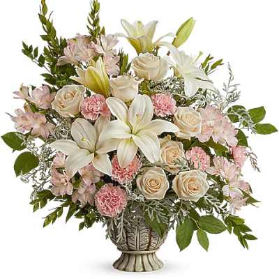 Arrangement of white lilies, cream roses, and pink flowers in a decorative vase