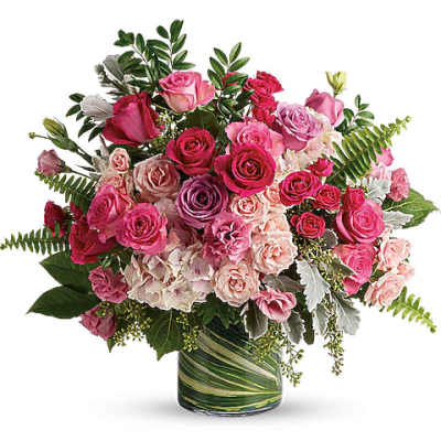 Pink and lavender rose bouquet in a striped glass vase