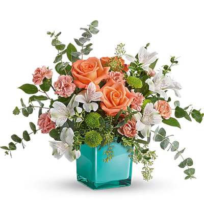 Peach roses and white alstroemeria in a turquoise glass vase