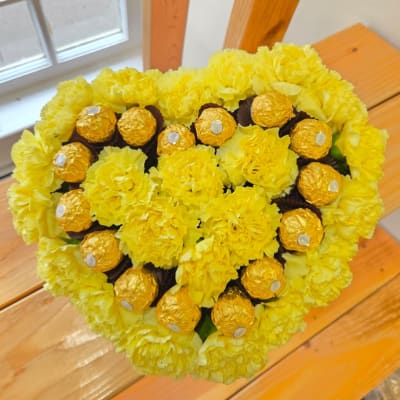 Yellow carnation bouquet with gold-wrapped chocolates