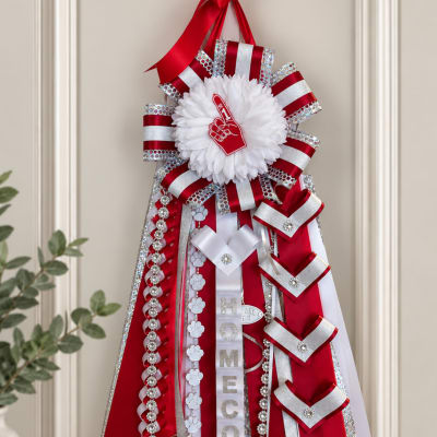 Red and white decorative ribbon display with a large white rosette and homecoming sign