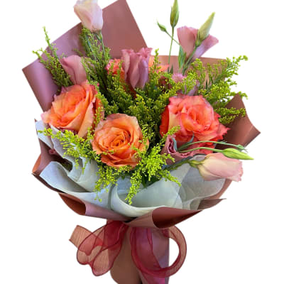 Bouquet of orange roses and pink lisianthus wrapped in paper