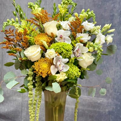 White and yellow floral arrangement in a tall vase