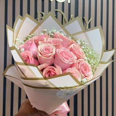 Pink roses wrapped in white and gold paper