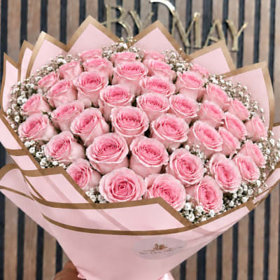 Bouquet of pink roses wrapped in pink and brown paper
