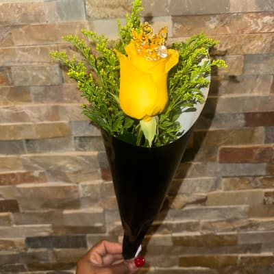 Single yellow rose bouquet with greenery in black wrap