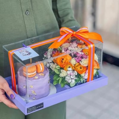Gift box with flowers and macarons under a clear cover