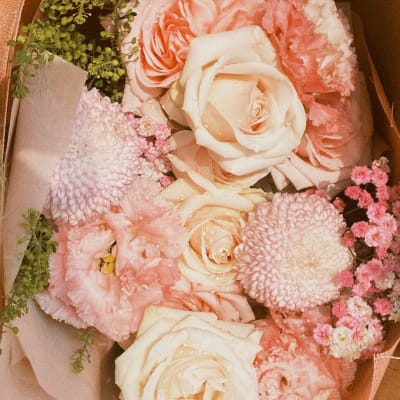 Bouquet of blush and cream roses with pink blooms in paper wrap