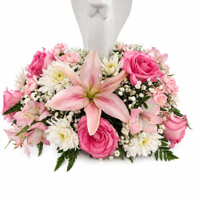 Pink and white floral arrangement with an angel figurine centerpiece