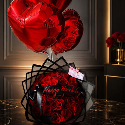Red rose bouquet with heart-shaped balloons and a Happy Birthday sign