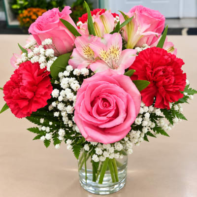 Pink roses and red carnations in a clear glass vase