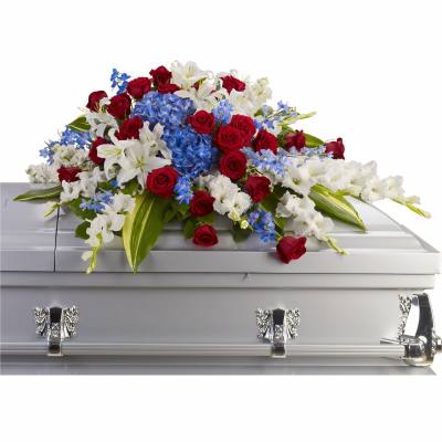 Red, white, and blue casket spray with roses, lilies, and hydrangeas on a silver casket