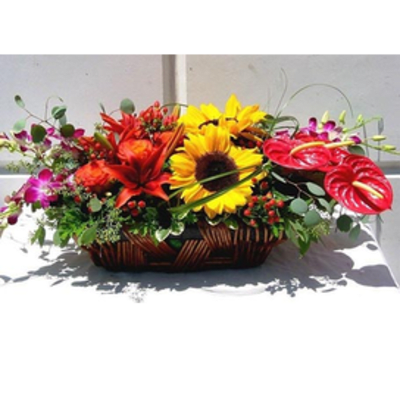 Basket arrangement with sunflowers, red lilies, and pink anthuriums