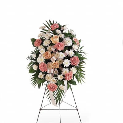 Standing spray of peach roses, pink carnations, and white daisies on a metal easel
