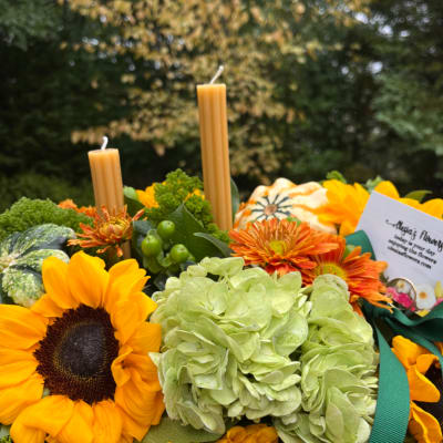 Sunflowers, green hydrangeas, and orange mums arranged with candles