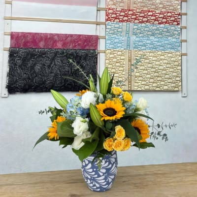 Sunflower and rose bouquet in a patterned vase