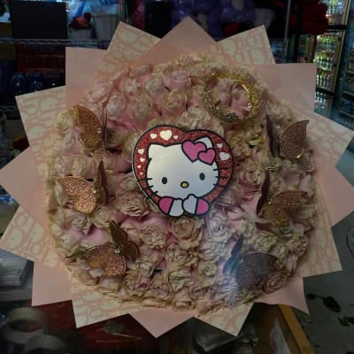 Pink rose bouquet with a Hello Kitty topper and butterfly decorations