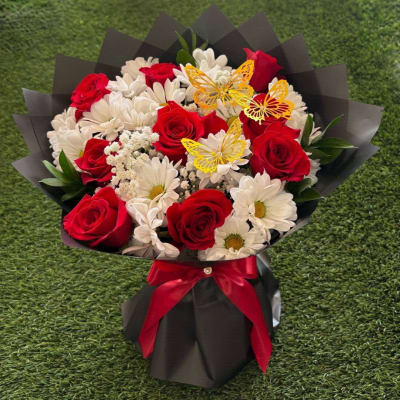 Bouquet of red roses and white daisies with yellow butterfly accents