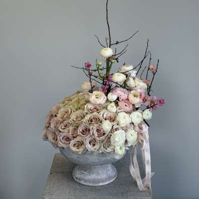 Large pastel rose arrangement in a gray pedestal vase