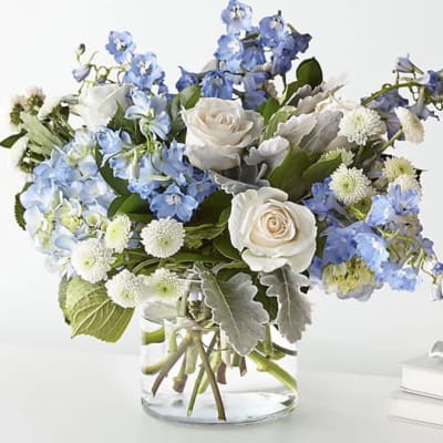 Blue and white flower arrangement in a clear glass vase