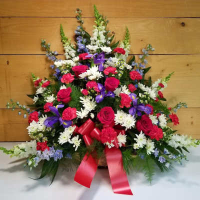 Large mixed flower basket with red ribbon and purple accents