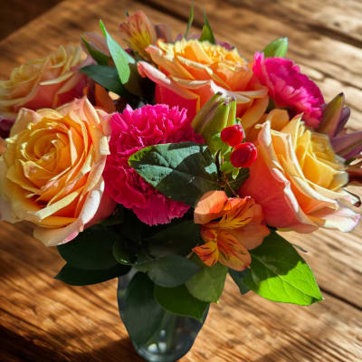 Bouquet of peach roses and pink carnations in a glass vase