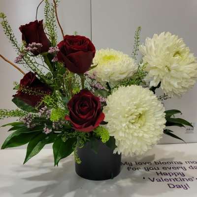 Red roses and white chrysanthemums in a black vase