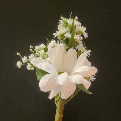 White daisy boutonniere with small filler flowers on a wrapped stem
