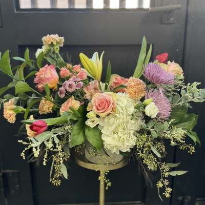 Mixed bouquet with pink roses, white hydrangea, and purple blooms in a vase