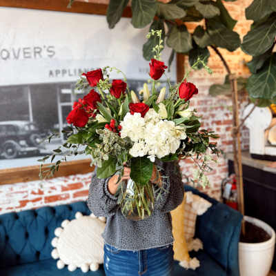 Bouquet of red roses and white hydrangeas in a glass vase