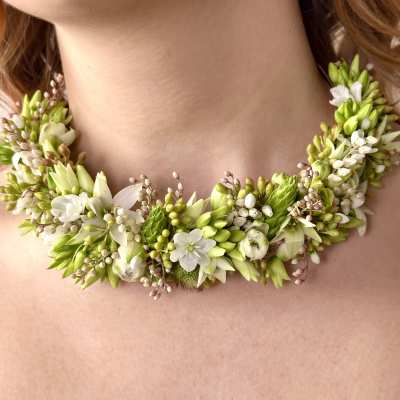 Floral necklace with white and green blossoms around the neck