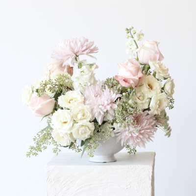 Blush and white floral arrangement in a white vase