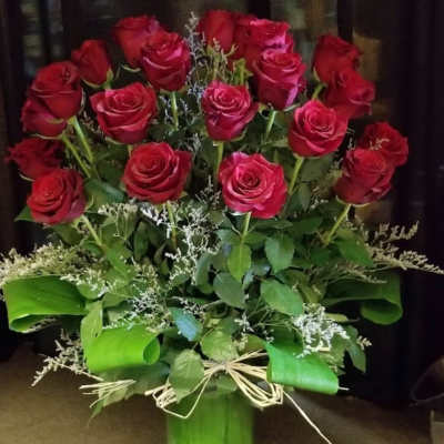 Bouquet of red roses in a tall green vase