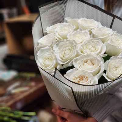 Bouquet of white roses wrapped in striped paper