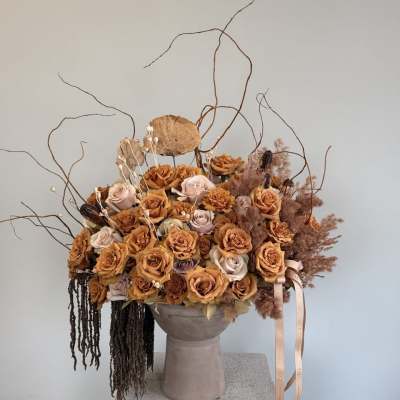 Large bouquet of peach and blush roses in a tall vase