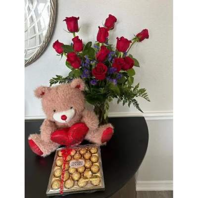 Bouquet of red roses with a teddy bear and chocolate box