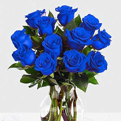 Blue roses arranged in a clear glass vase
