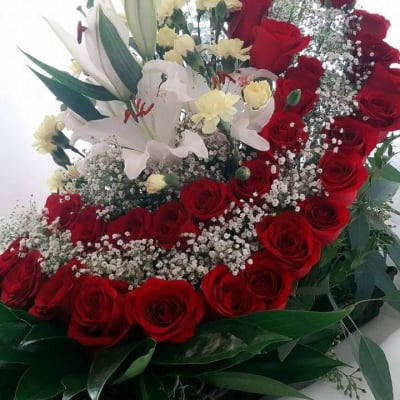 Red roses and white lilies arranged with baby's breath