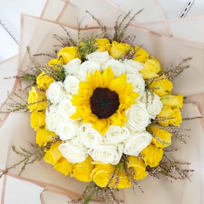 Bouquet of yellow and white roses with a sunflower center