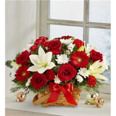 Basket arrangement of red roses, white lilies, and red daisies with a ribbon