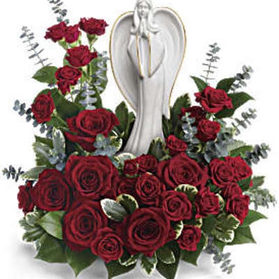 Red roses arranged around a white angel figurine