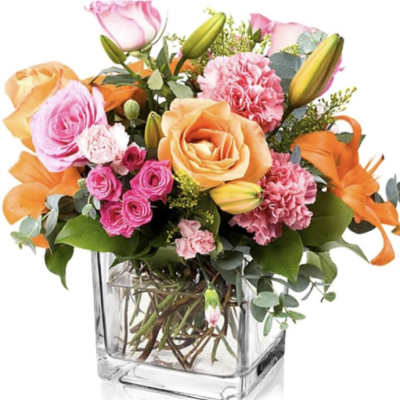Bouquet of pink and orange flowers in a clear glass vase