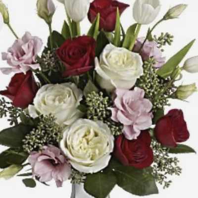 Bouquet of red, white, and pale pink roses in a white vase