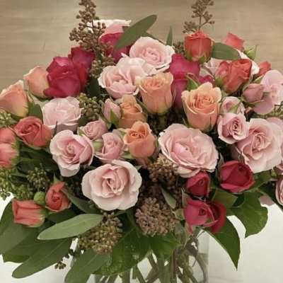 Bouquet of pink and peach roses in a clear glass vase