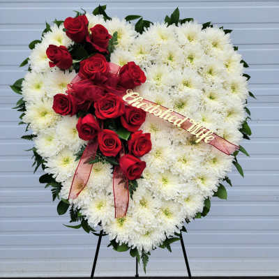 Heart-shaped white chrysanthemum wreath with red roses and ribbon